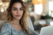 © Vera - close-up shot of a young woman sitting on a couch using a laptop.