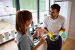 © Drazen - Happy couple talking while doing  dishes together.