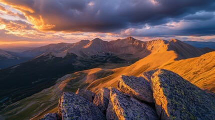 Wall Mural - A stunning sunset over rugged mountains, showcasing vibrant colors and dramatic cloud formations.