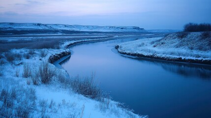 Wall Mural - A tranquil winter river scene with snow-covered banks and soft evening light.