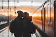 © Spicy World - Couple sharing a kiss at a train station during sunset in winter