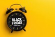 © David Zarzosa - A retro alarm clock with the words 'Black Friday Super Sales' on yellow background with copy space, promoting retail discounts.