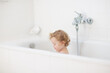 © famveldman - Little baby in bath tub playing with soap foam