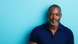 © Irina Kozel - A confident mid-40s African-American man with silver-gray hair styled in short twists, wearing a navy blue shirt against a light blue background