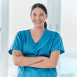 © peopleimages.com - Portrait, nurse and happy woman with arms crossed for healthcare career, pride and service in hospital. Face, smile and confident medical professional, employee and expert surgeon working in Spain