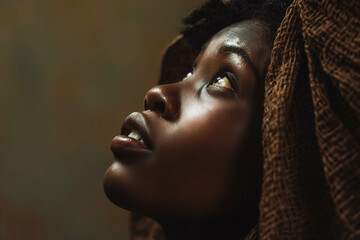 Biblical character. Close up portrait of a black woman with a shawl looking up.