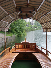 covered boat on a lake in slovenia with trees in the backgroun