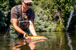 © Ivi - Powerlightss - Man releasing trout back into river after catch