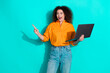 © deagreez - Photo of smart woman with wavy hairstyle dressed shirt hold laptop indicating look empty space isolated on turquoise color background