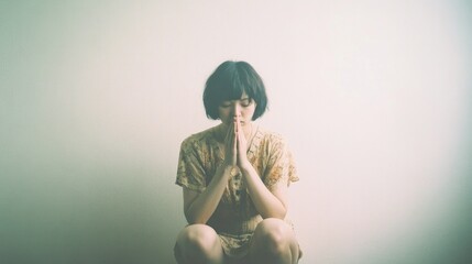 Asian woman praying in front of white background, vintage tone.