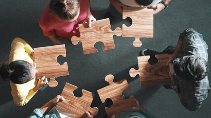 Sticker - Top down view of business people gathering jigsaw together at meeting. Aerial view of diverse team collect or put piece of jigsaw puzzle together and standing while wearing casual cloth. Symposium.