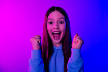 Poster - Photo of shiny lucky little lady dressed hoodie risinf fists empty space isolated neon pink color background