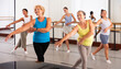 © JackF - Dancing active women engaged in a group class practice energetic dance in a modern dance studio
