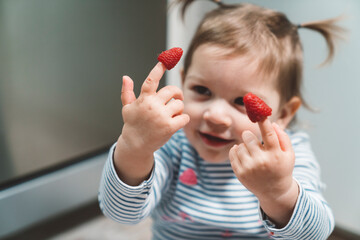 The baby is trying a new taste of solid food. Eating healthy food from the beginning is important. Young child doesn't want to eat vegetable and fruit.