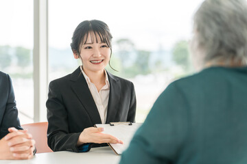 Wall Mural - シニア女性に書類の説明をするビジネスウーマンとビジネスマン
