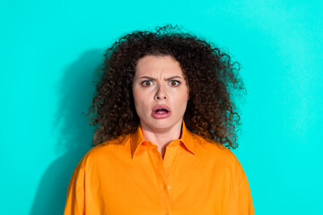 Wall Mural - Photo of speechless offended woman with wavy hairstyle dressed orange t-shirt astonished staring isolated on turquoise color background