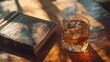 © Suthathip - Whiskey on the rocks in a crystal tumbler, the amber liquid catching the light. The tumbler is set on a polished mahogany table with a vintage leather-bound book beside it,
