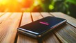 © LU - Close-up of a modern smartphone with a battery indicator showing full charge, placed on a wooden table. The background is softly blurred, focusing on the device's safety features