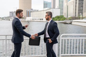 Two business men shaking hands close up. Two successful businessmen shake hands in celebration of merger and acquisition - symbolizing teamwork, negotiation, and partnership. Businessmen Shaking Hands