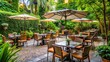 © nittiya - Restaurant set in a lush garden with tables, chairs, and umbrellas