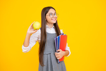 Wall Mural - Back to school. Teenager schoolgirl with bag hold apple and book, ready to learn. School children on isolated yellow background.