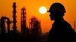 © Pixel Alchemist - Silhouette of a worker in a hard hat against an industrial sunset, symbolizing safety and diligence in the workplace.