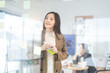 © dodotone - Business asian woman using glass board note ideas paper at indoors office