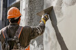 © Maxky - Rear view of a plasterer plastering a cement wall.