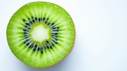 Wall Mural - A slice of kiwi with its bright green flesh and black seeds, isolated on a white surface for a fresh, vibrant look