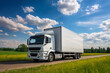 © soleg - A white truck is driving on the road against the background of a summer landscape