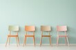 © Zography - Four pastel-colored chairs arranged in a row against a light teal background, representing minimalist Scandinavian decor.