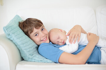 Wall Mural - child watching newborn baby in bassinet.
