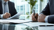 © Milagro - Closeup of two businessmen signing documents at a conference table.