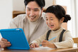 © amanaimages - タブレットPCで学習をする女の子と父親