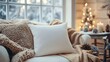 © Coosh448 - Winter mockup of a plain pillow on a cozy armchair by a snow-covered window, with a warm blanket and holiday decor nearby, ideal for home decor designs. 4K hyperrealistic photo.