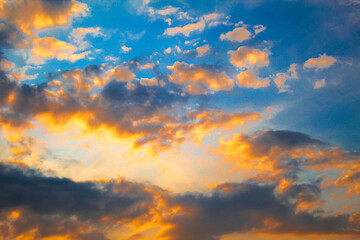 The exotic sunset and blue orange clouds have a cheerful feel. Textured sky view image. The perfect summer wallpaper. Clear epic sky. Dramatic evening light and fiery orange sunsets. 