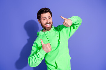 Poster - Photo portrait of handsome mature age funky man in neon hoodie showing likes thumbs up respect for party isolated on violet color background