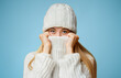 © Prostock-studio - Blonde girl in winter clothes covering her face with sweater, warming up during cold season, yellow background