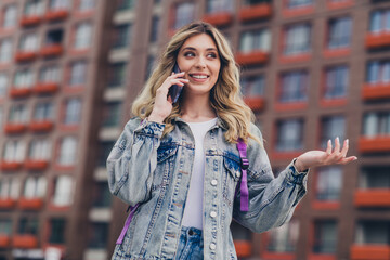 Sticker - Portrait of pretty young girl chatting phone backpack wear denim jacket walk street outdoors