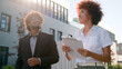 © Yuliia - Indian man Arabian businessman investor client and African American woman realtor saleswoman businesswoman talking walking in city looking at modern urban buildings business discussing investment