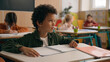 © Yuliia - African American school boy son child guy little kid schoolboy pupil student study learn elementary education studying learning class lesson answer teacher question talk nod head yes talking agree