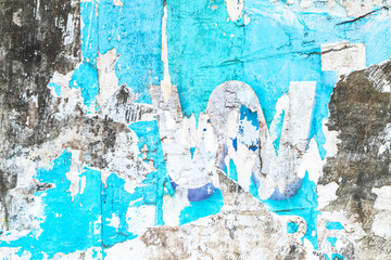 wall with torn blue paper patches glued