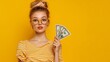 © Sanych - Photo of lovely young lady hold money fan point empty space dressed stylish striped yellow garment