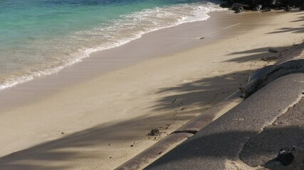 Wall Mural - Waves gently rolling on a white-sand beach, wide steady footage