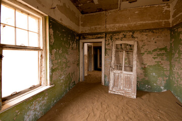 Abandoned industrial building in the old mining town of Kolmanskop in Namibia with crumbling walls and sand invading the interior