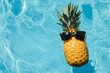 © Halina Berah - Summer pineapple wearing sunglasses floating in a swimming pool. Stock