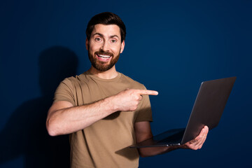 Sticker - Photo of brunet hair software engineer man in beige t shirt pointing finger laptop recommend job online isolated on dark blue color background