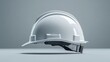 © Влада Яковенко - A sleek white hard hat is displayed from a side perspective on a simple gray background, perfect for construction or industrial-themed stock photography