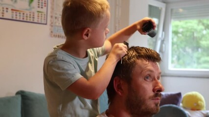 Wall Mural - Father and child. Cute boy with Down Syndrome is cutting his father's hair. Home family time and fun.