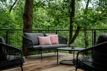 With pastel pink pillows and blanket, a cozy wooden terrace features a grey sofa and grey pillows